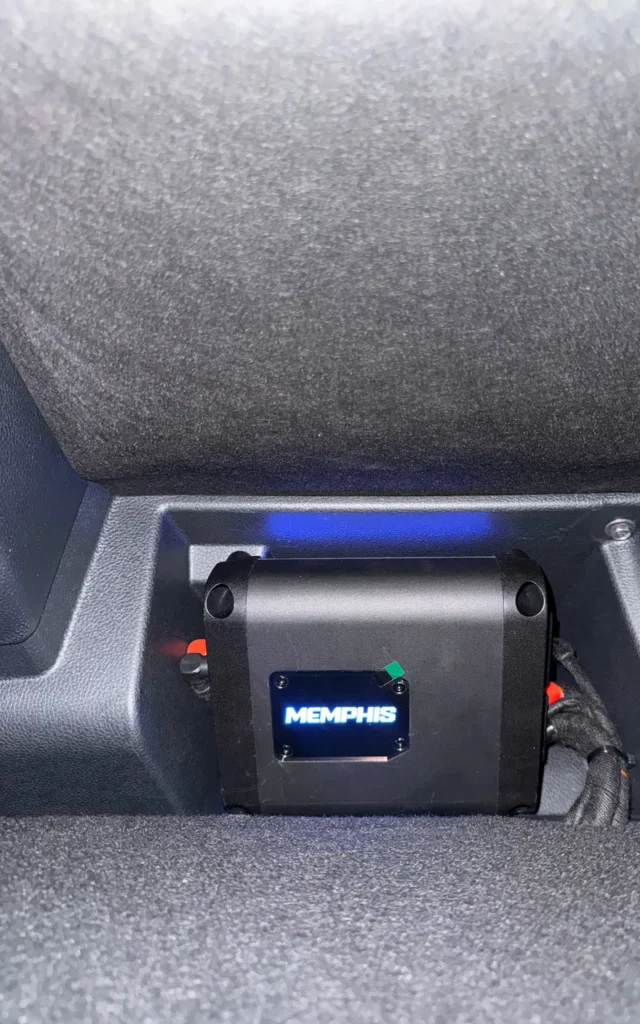 Illuminated amplifier installed in a vehicle.