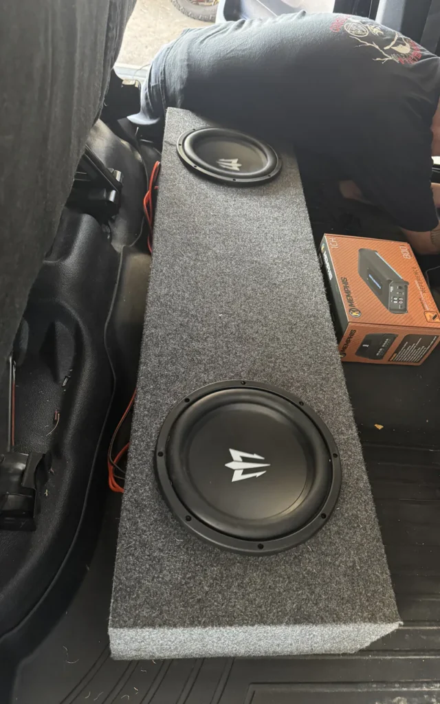 Custom subwoofer enclosure installed in a vehicle.