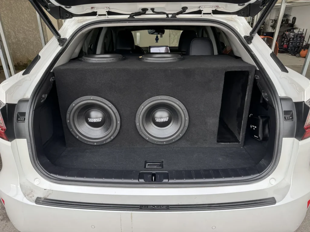 Dual subwoofers installed in a vehicle trunk.